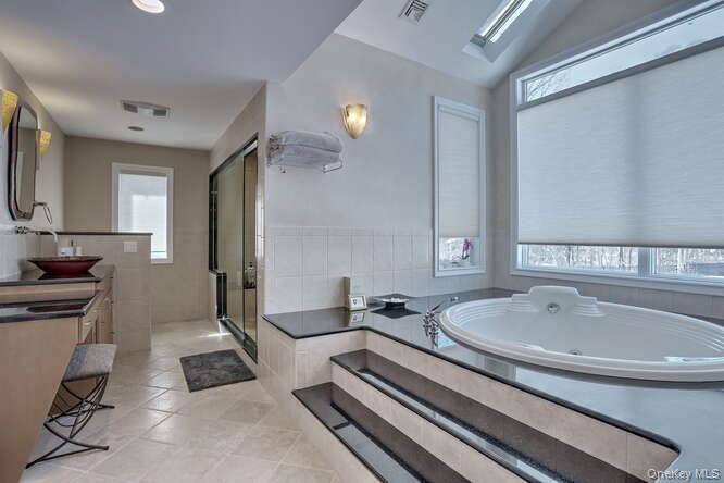 89 Spook Rock Road Suffern, NY 10901 - Photo 20 of 42 a spacious bathroom with a sink a mirror and a bathtub