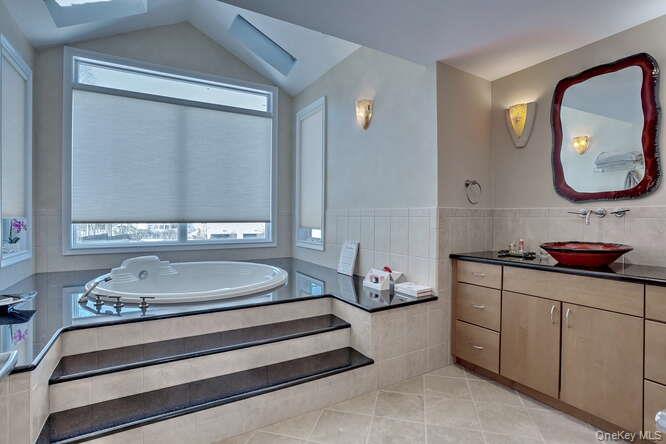 89 Spook Rock Road Suffern, NY 10901 - Photo 22 of 42 a bathroom with a double vanity sink and a mirror