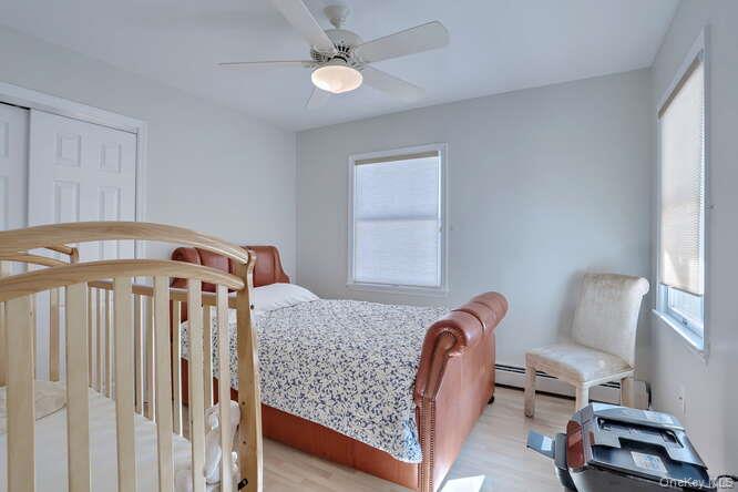 89 Spook Rock Road Suffern, NY 10901 - Photo 28 of 42 a bedroom with a bed a chandelier and a window