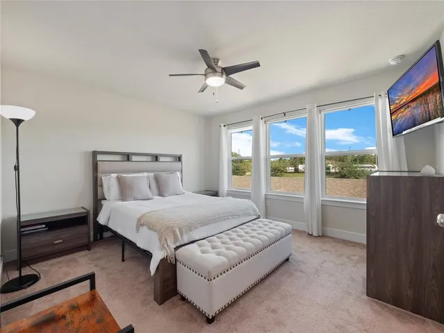 a spacious bedroom with a bed and large window