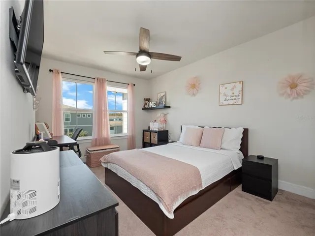 a bedroom with a large bed and a flat tv screen on dresser