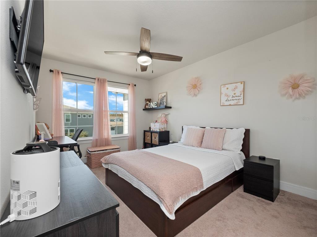 11018 Leafshore Loop Orlando, FL 32829 - Photo 15 of 24 a bedroom with a large bed and a flat tv screen on dresser