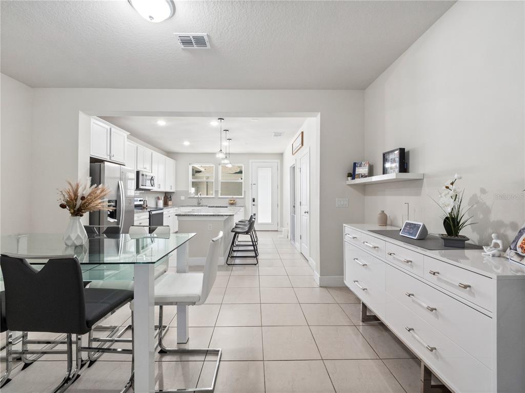 11018 Leafshore Loop Orlando, FL 32829 - Photo 7 of 24 a kitchen with stainless steel appliances kitchen island granite countertop a refrigerator and cabinets