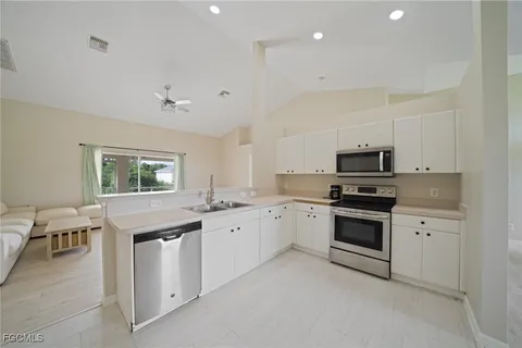 a kitchen with granite countertop appliances cabinets and a sink