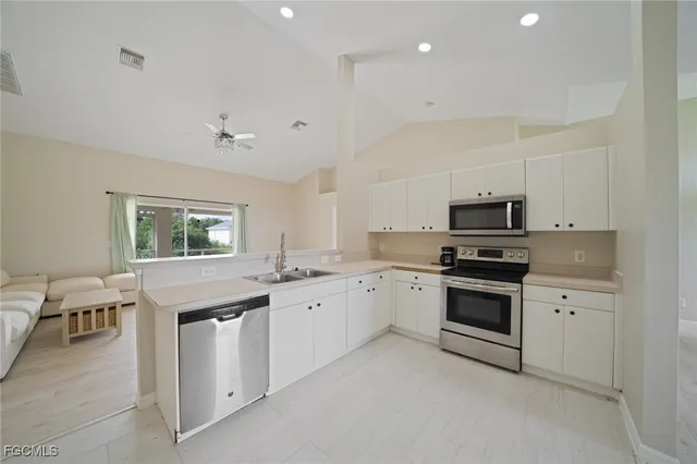 a kitchen with granite countertop appliances cabinets and a sink