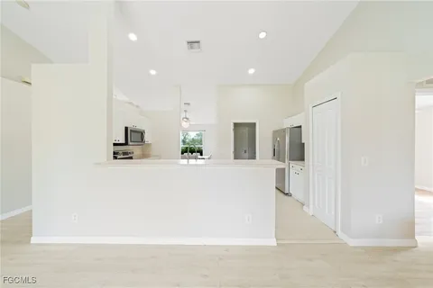 a view of kitchen with kitchen island and stainless steel appliances