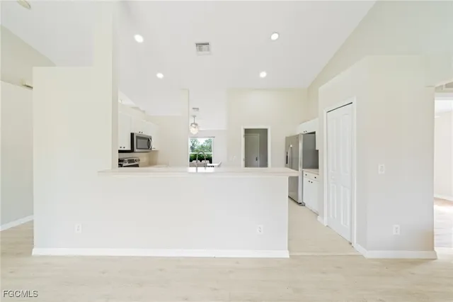 a view of kitchen with kitchen island and stainless steel appliances