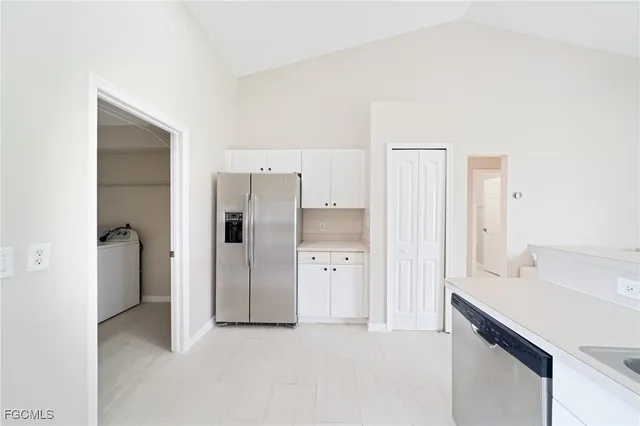 a view of a kitchen with a sink and refrigerator