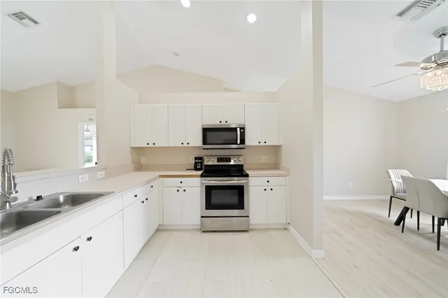 a kitchen with granite countertop white cabinets and white appliances
