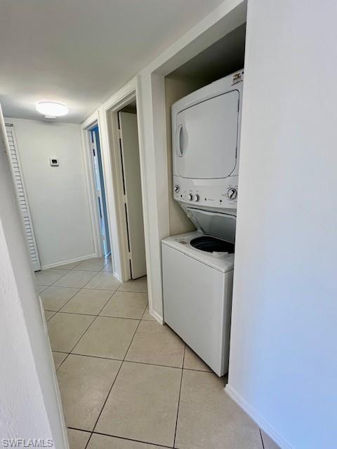 1075 Foxfire Lane, Unit 101 Naples, FL 34104 - Photo 7 of 12 Clothes washing area with stacked washer / dryer, laundry area, baseboards, and light tile patterned floors