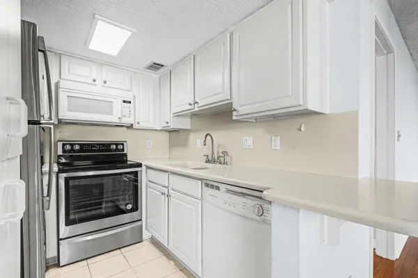 a kitchen with stainless steel appliances granite countertop a stove a microwave and a refrigerator