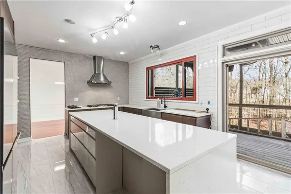 a large kitchen with stainless steel appliances a large counter top