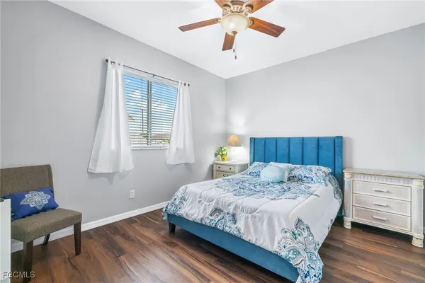a bedroom with a bed chandelier and a window