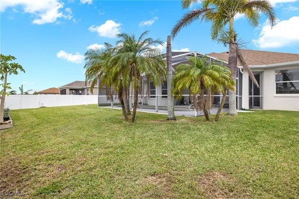 a palm tree sitting in front of a house with a big yard