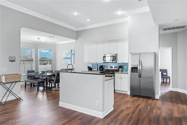 a kitchen with wooden floors and stainless steel appliances