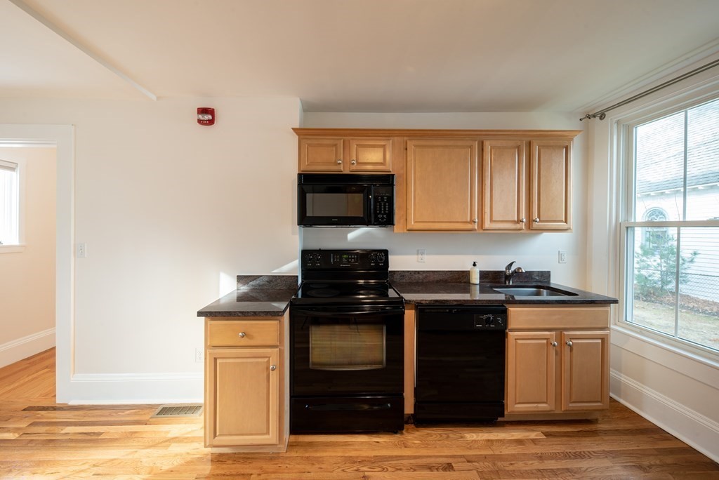 146 Lincoln Road, Unit A Lincoln, MA 01773 - Photo 2 of 11 a kitchen with stainless steel appliances granite countertop a stove and a sink