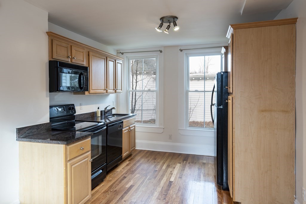146 Lincoln Road, Unit A Lincoln, MA 01773 - Photo 3 of 11 a kitchen with granite countertop a refrigerator stove top oven and sink