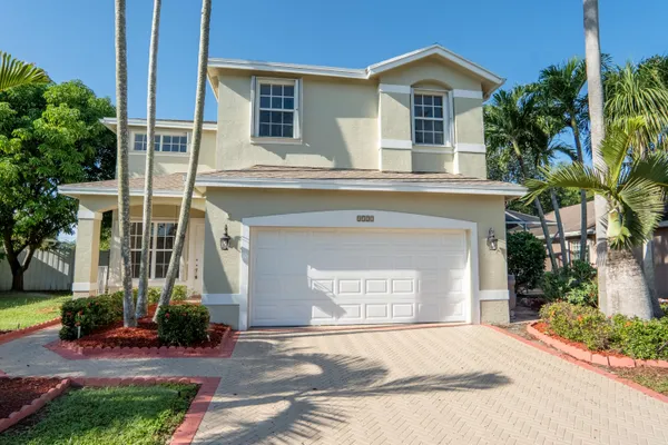 a front view of a house with a yard and garage