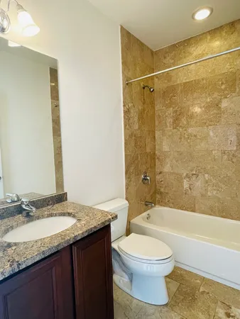 a bathroom with a granite countertop sink toilet and shower