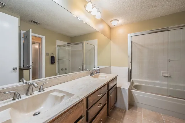 a bathroom with a granite countertop sink mirror and a bath tub
