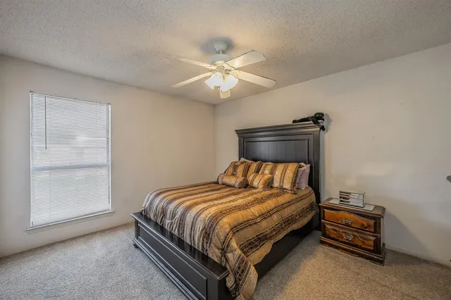 a bed sitting in a bedroom next to a window and a chandelier