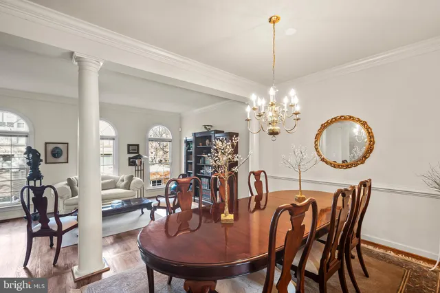 a dining room with furniture a chandelier and wooden floor