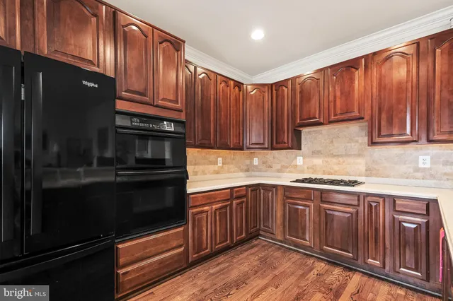 a kitchen with granite countertop wooden cabinets and stainless steel appliances