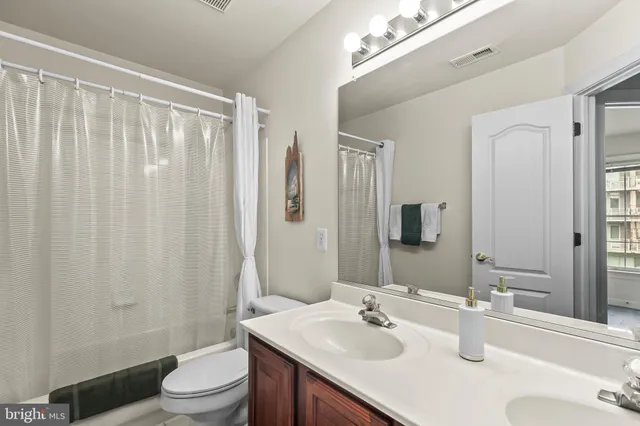 a bathroom with a sink vanity mirror and toilet