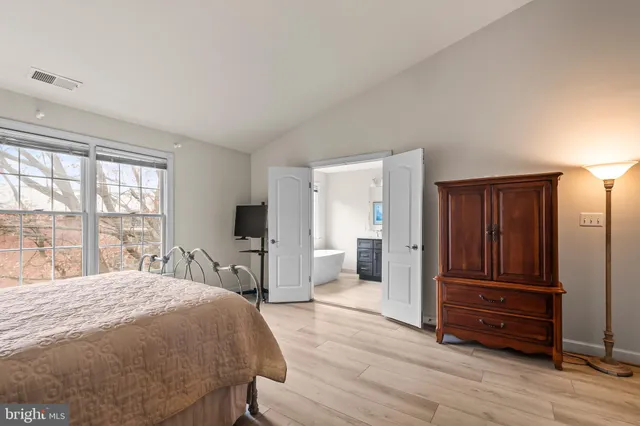 a bedroom with a bed and wooden floor