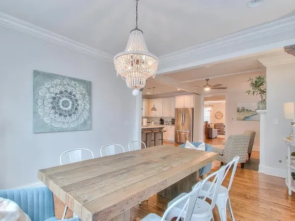 a kitchen with stainless steel appliances granite countertop a sink a stove a refrigerator and island with wooden floor