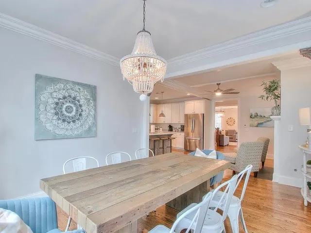 a kitchen with stainless steel appliances granite countertop a sink a stove a refrigerator and island with wooden floor