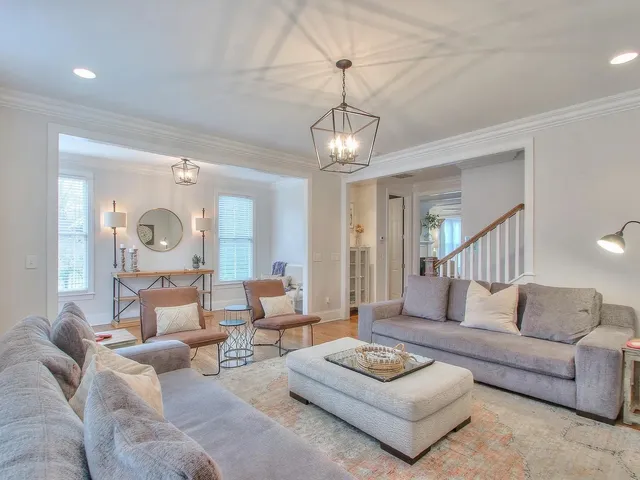 a living room with furniture a rug and a chandelier