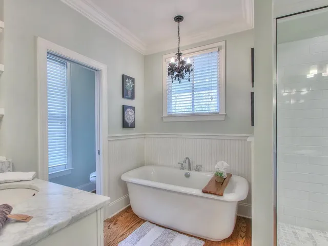 a bathroom with a granite countertop sink a large mirror and a shower