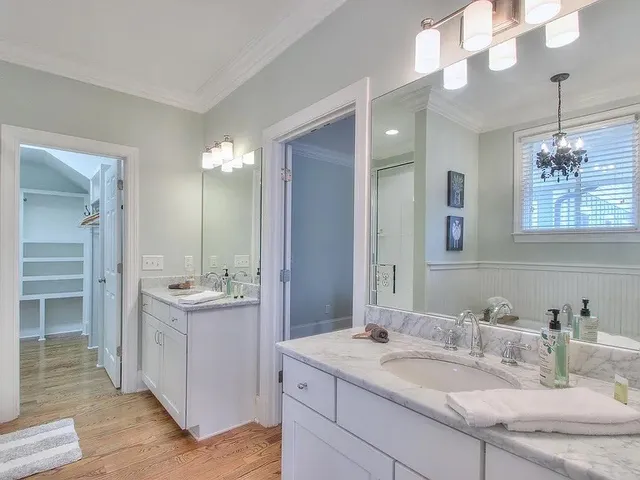 a bathroom with a granite countertop sink a mirror and a shower