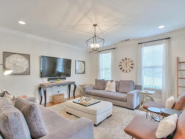 a living room with furniture a flat screen tv and a large window