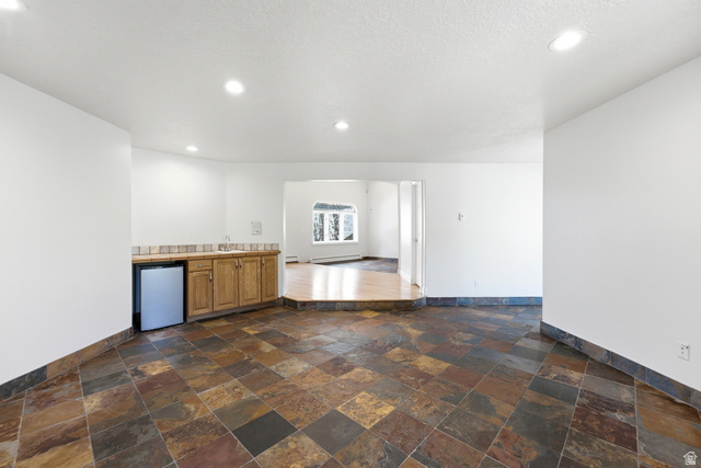 3535 Homestead Road Park City, UT 84098 - Photo 11 of 81 Spacious lower level featuring multicolor slate tile flooring and a built-in wet bar with wood cabinetry, a sink, and a compact refrigerator