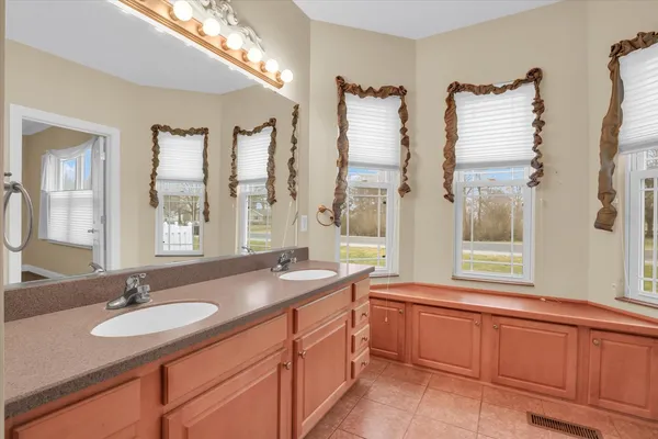 a bathroom with a granite countertop sink and a large mirror