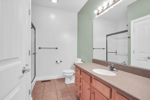 a bathroom with a granite countertop sink toilet and shower