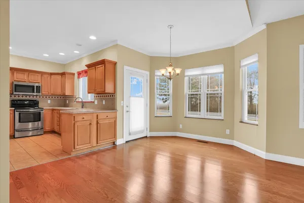 a kitchen with stainless steel appliances granite countertop a refrigerator a stove a sink dishwasher with a dining table and chairs