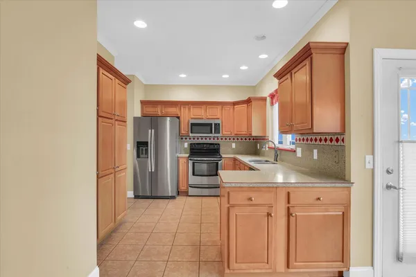 a kitchen with stainless steel appliances granite countertop a refrigerator and a stove