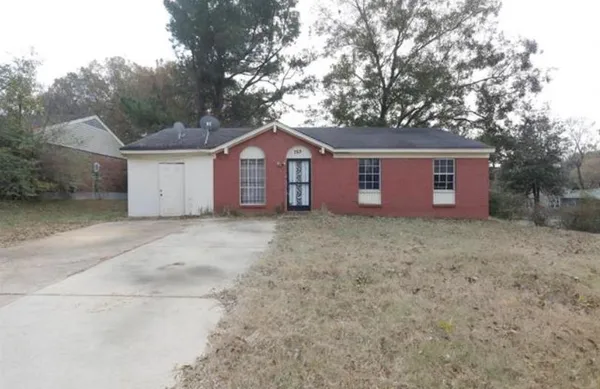 a view of a house with a yard and large tree