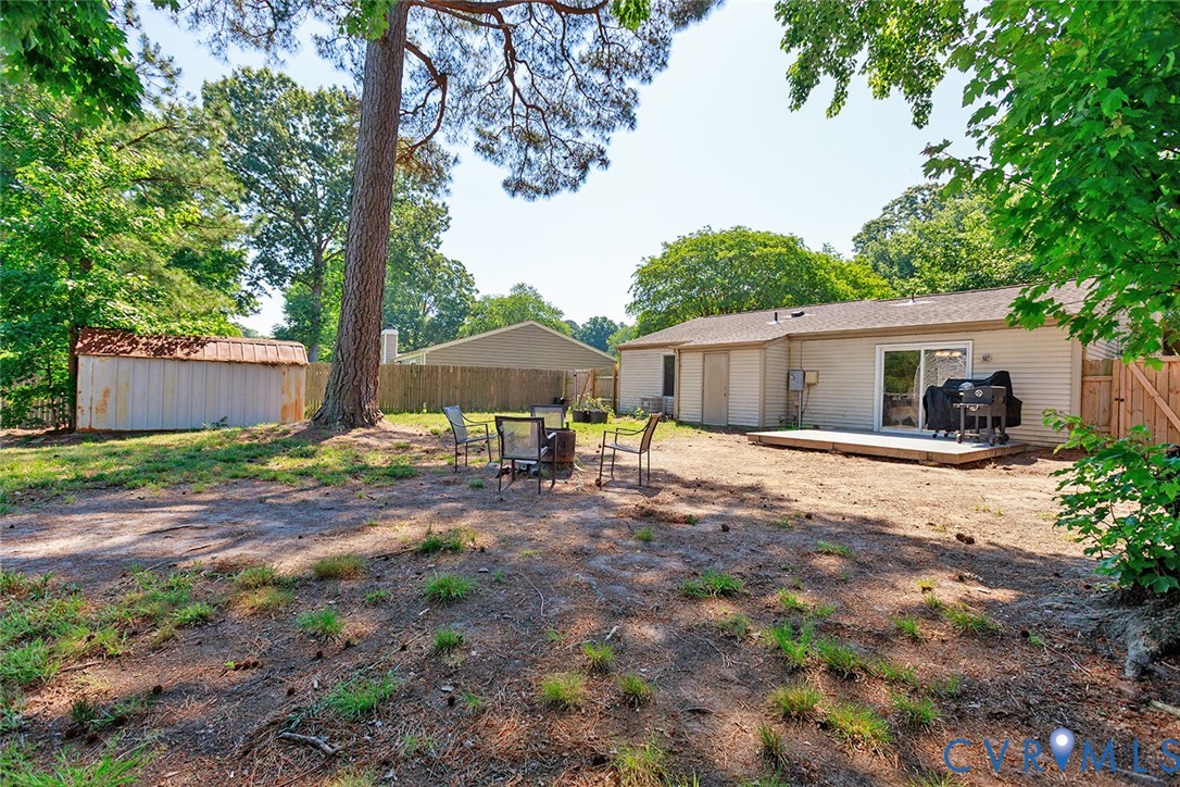 925 Fluvanna Road Newport News, VA 23601 - Photo 23 of 25 a backyard of a house with table and chairs under an umbrella
