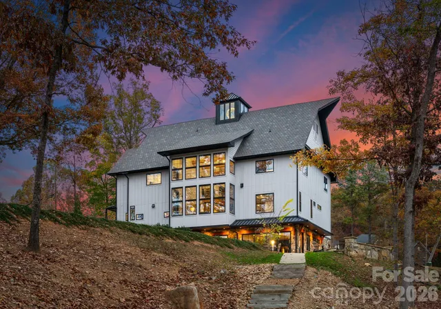 a view of a white house with a large tree