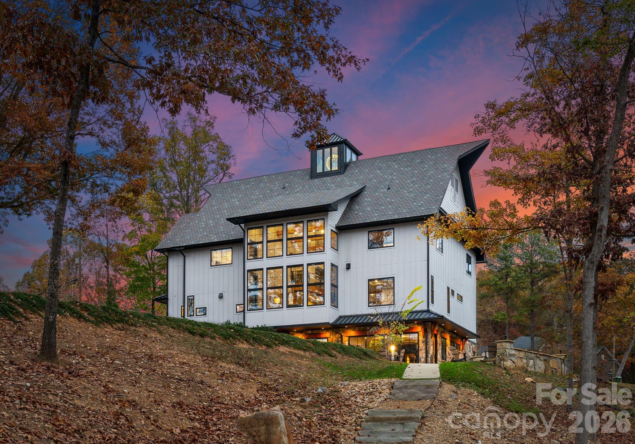 a view of a white house with a large tree