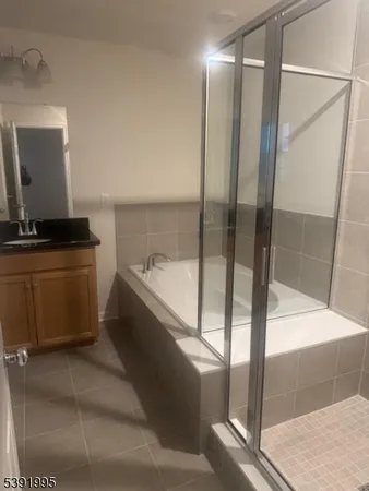 a bathroom with a tub sink and mirror