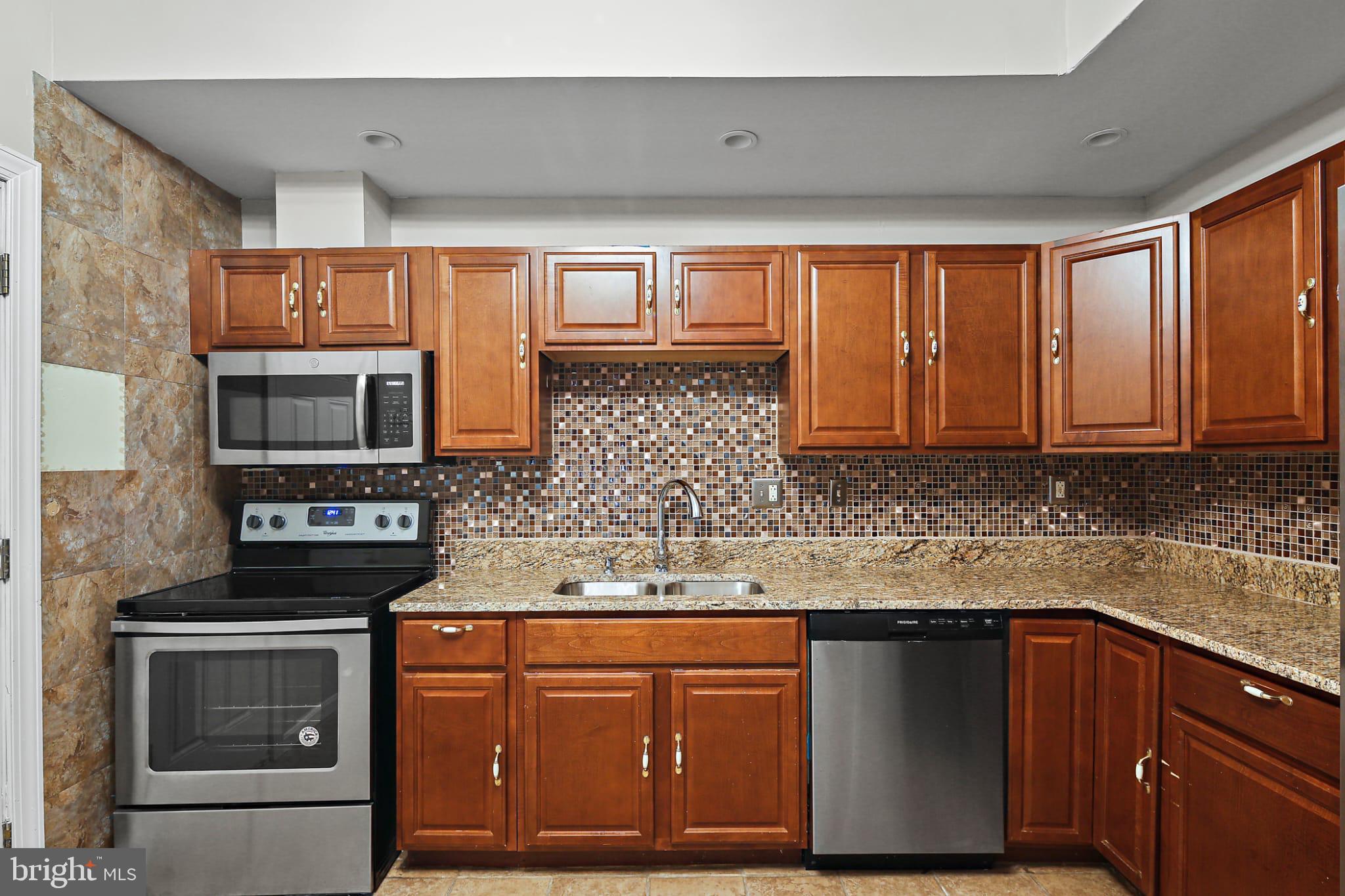 3924 Reisterstown Road Baltimore, MD 21215 - Photo 9 of 25 Modern kitchen with rich wood cabinetry.