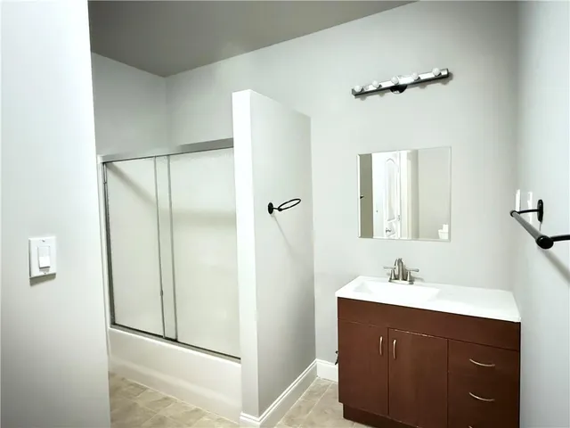a bathroom with a double vanity sink mirror and shower