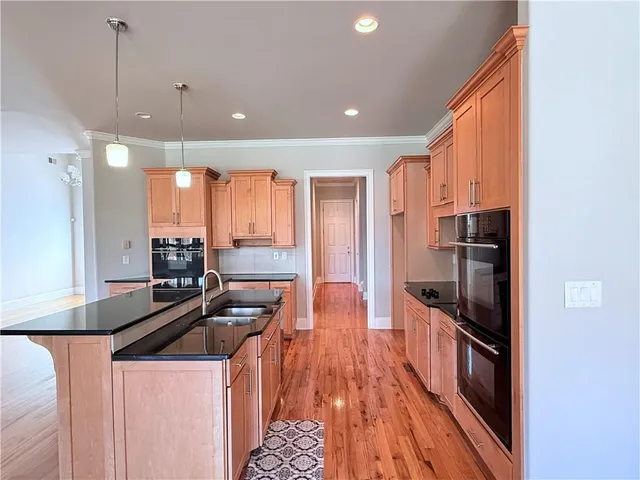 a kitchen with stainless steel appliances granite countertop a stove a sink and a refrigerator