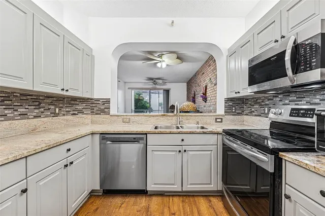 a kitchen with stainless steel appliances granite countertop a sink and cabinets