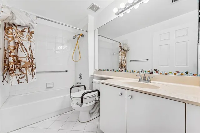 a bathroom with a granite countertop sink a mirror and a bathtub